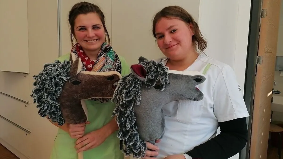 Klara Köll und Laura Pranter zeigen stolz ihr im Zuge der Assistentenaussbildung selbstgenähtes Steckenfpferd