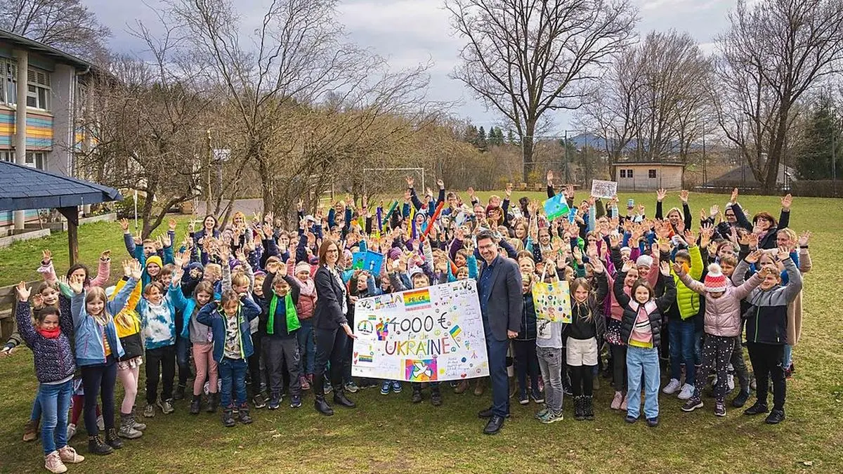 Caritas-Direktor Ernst Sandriesser, Volksschuldirektorin Renate Otti, ihr Team und die engagierten Schülerinnen und Schüler