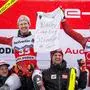 Winner Austria's Manuel Feller (C-R) and third-placed Austria's Dominik Raschner (C-L) pose with a message to their injured teammate Marco Schwarz during the podium ceremony of the Men's Slalom event during the FIS Alpine Ski World Cup in Adelboden, southwestern Switzerland, on January 7, 2024. (Photo by Fabrice COFFRINI / AFP)