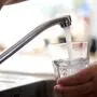 Frisches Leitungswasser fließt sprudelnd aus einem Wasserhahn in ein Glas