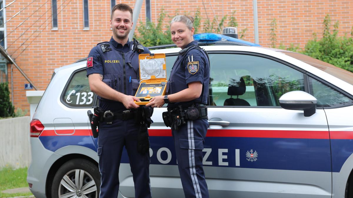 Petra und Johannes von der Klagenfurter Polizei mit einem Defibrillator