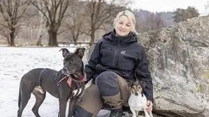 Eine Frau und ein Hund posieren für ein Foto in einer verschneiten Landschaft | Nina Hofmann mit Pflegehund Bruno und Happy beim Training im Klagenfurter Europapark