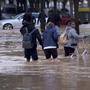 Menschen waten durch die überschwemmten Straßen von Valencia