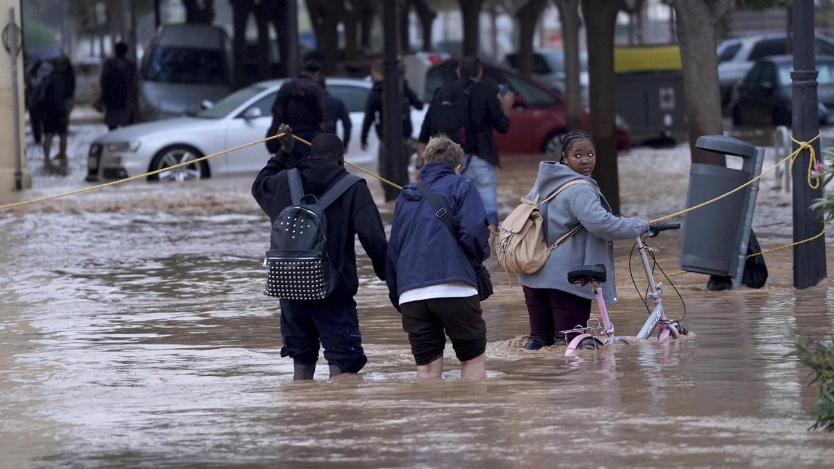 Menschen waten durch die überschwemmten Straßen von Valencia