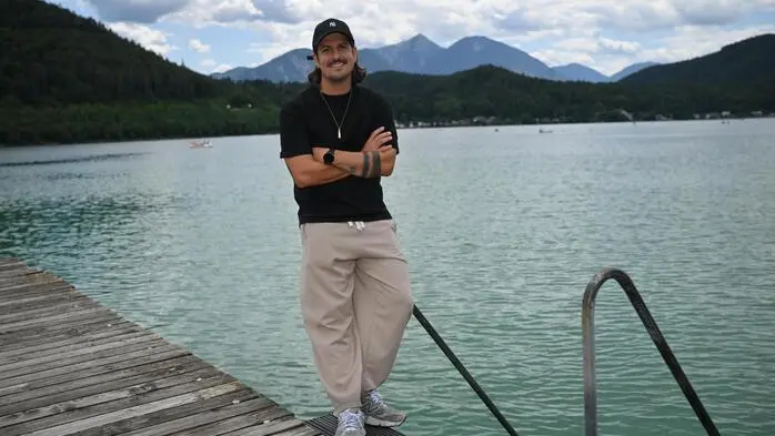 Der Moderator steht am Steg, hinter ihm der See