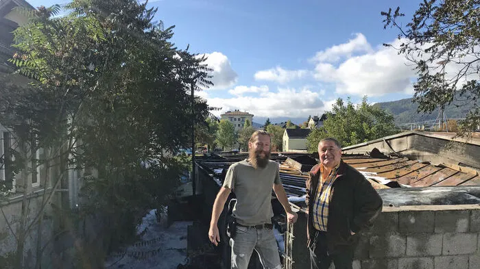 Hannes Kollegger (rechts) und Richard Innerhofer begannen mit den Löscharbeiten. Hinter ihnen die ausgebrannte Lagerhalle. Links die Rückseite der Wäscherei Masser, wo schon die Bäume Feuer fingen