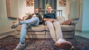 Zwei Männer sitzen auf einer Couch und lachen in die Kamera | Marijan Tatschl und Stefan Koller produzieren Musik im Lavanttal (von links)