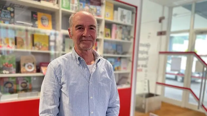 Ein Mann steht vor einem Bücherregal