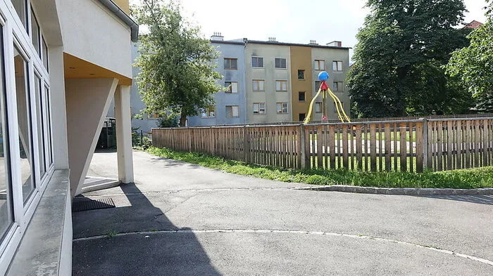 Ein keilförmiges Stück des Schulgartens (hinter dem Zaun) soll dem Behindertenparkplatz weichen
