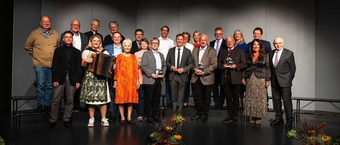 Viele Menschen stehen in Reih und Glied auf einer Bühne