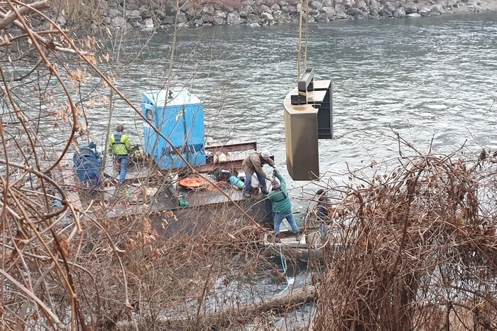 Mithilfe des Floßes wird der Rammschutz zur Insel gebracht und dort montiert.