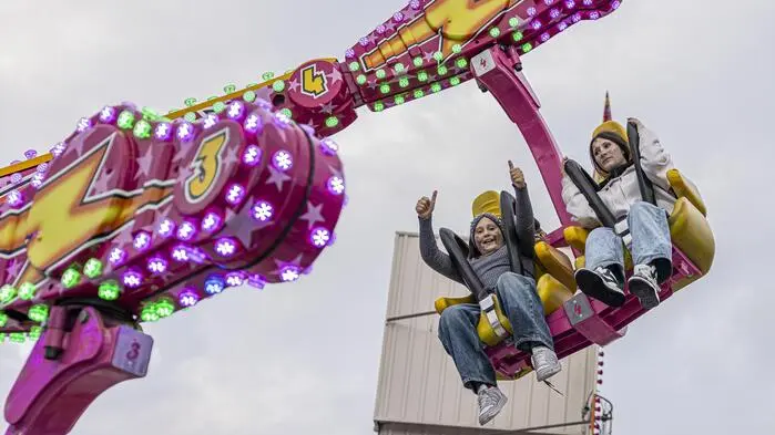 Zwei Kinder sitzen in einem Fahrgeschäft am St. Veiter Wiesenmarkt.