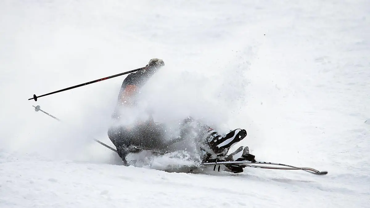 Man riding on skis fall down, he could break something.