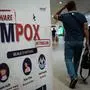A passenger walks past a banner informing about Monkeypox (MPOX) at Soekarno-Hatta International Airport in Tangerang on August 26, 2024. Formerly known as monkeypox, mpox is an infectious disease caused by a virus transmitted to humans by infected animals that can also be passed from human to human through close physical contact. (Photo by YASUYOSHI CHIBA / AFP)
