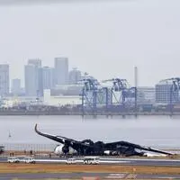 Beim Zusammenstoß eines Airbus A350 von Japan Airlines und einer Bombardier Dash 8-300 der japanischen Küstenwache am Flughafen Tokio-Haneda gab es Tote und Verletzte. Beamte untersuchen das verbrannte Airbus-A350-Flugzeug 