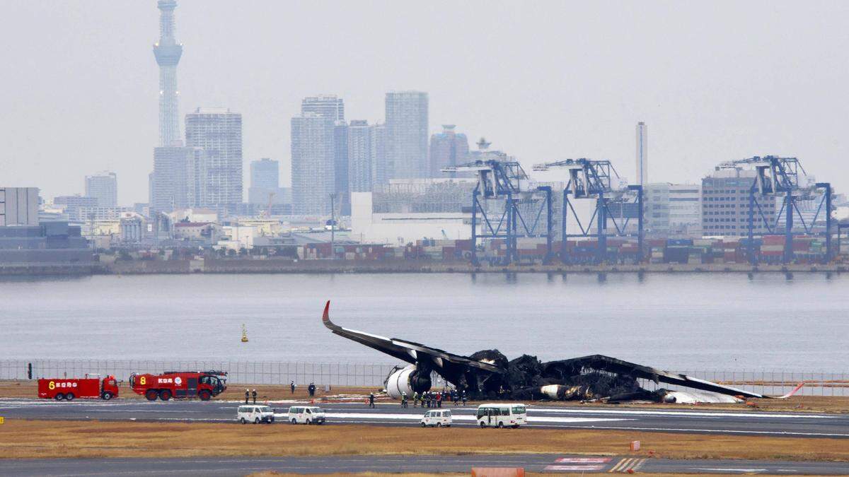 Das Wrack des ausgebrannten Airbus | Beim Zusammenstoß eines Airbus A350 von Japan Airlines und einer Bombardier Dash 8-300 der japanischen Küstenwache am Flughafen Tokio-Haneda gab es Tote und Verletzte. Beamte untersuchen das verbrannte Airbus-A350-Flugzeug 