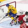 Sweden forward Lucas Raymond Lucas (18) is stopped by Austria goalie Sebastian Wraneschitz (1) during the first period of an IIHF World Junior Hockey Championship game in Edmonton, Alberta, Monday, Dec. 28, 2020. (Jason Franson/The Canadian Press via AP)