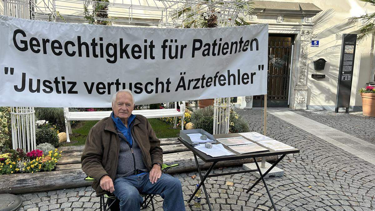 Mit einem Banner macht Fritz Pirker vor dem Rathaus auf sein Anliegen aufmerksam