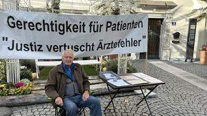 Mit einem Banner macht Fritz Pirker vor dem Rathaus auf sein Anliegen aufmerksam