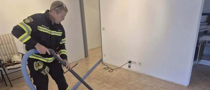 Ein Feuerwehrmann beim Entfernen des stehenden Wassers