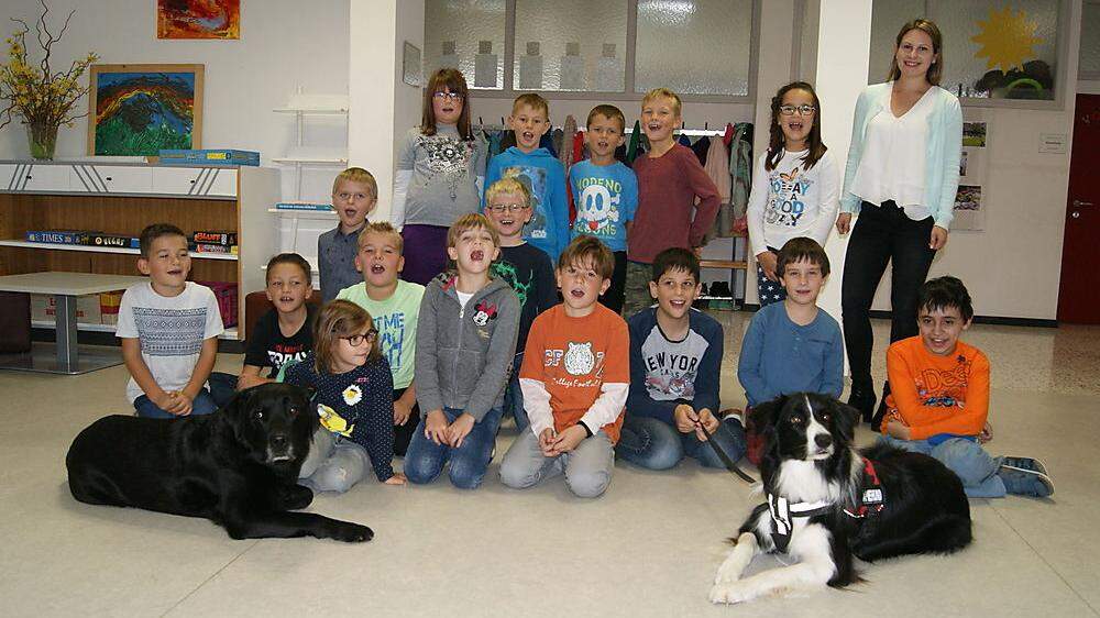 Angelika Vogl (rechts hinten) mit den Therapiehunden Rico (links) und Aidan sowie den Schülern 