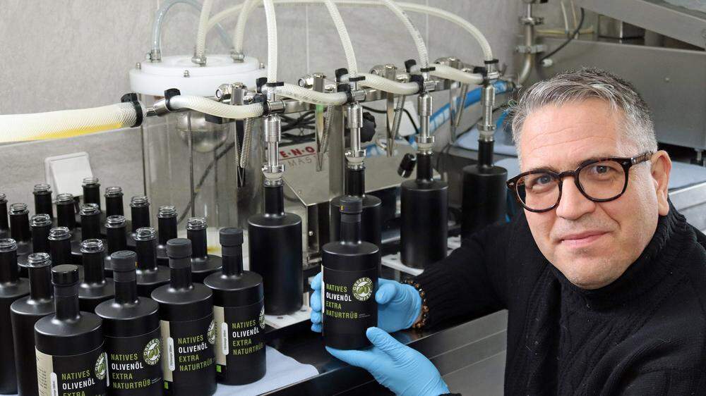 Michael Glatz mit dem naturtrüben Bio-Olivenöl und der neuen Abfüllmaschine