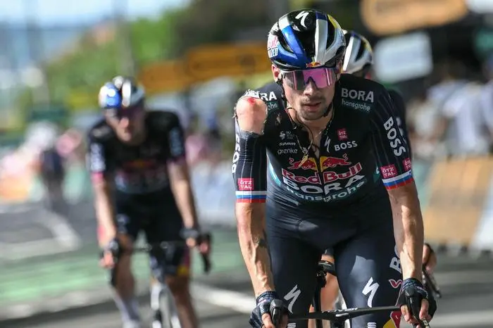 (FILES) Red Bull - BORA - hansgrohe team's Slovenian rider Primoz Roglic, with visible injuries sustained in a crash in the final kilometers of the stage, cycles past the finish line of the 12th stage of the 111th edition of the Tour de France cycling race, 203,6 km between Aurillac and Villeneuve-sur-Lot, southwestern France, on July 11, 2024. Leading contender Primoz Roglic has withdrawn from the Tour de France before the start of stage 13, his team Red Bull Bora Hansgrohe said on July 12, 2024. (Photo by Marco BERTORELLO / AFP)