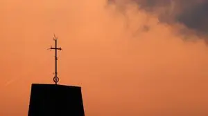 Ein Kreuz steht auf dem Dach einer Kirche vor Abendhimmel. Der Kirchenaustritt ist die vom Bürger auf eigenen Wunsch veranlasste Beendigung der staatlich registrierten Mitgliedschaft in einer Kirche. Themenbild, Symbolbild Frechen, 08.05.2024 NRW Deutschland *** A cross stands on the roof of a church against the evening sky Leaving the church is the termination of state-registered membership of a church at the citizens own request Themed image, symbolic image Frechen, 08 05 2024 NRW Germany Copyright: xChristophxHardtx