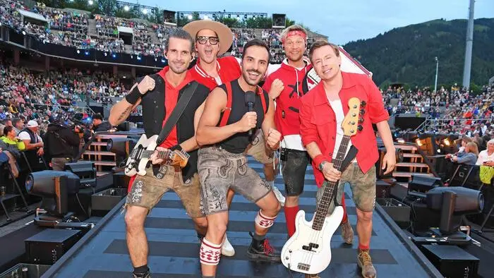 Fünf Bandmitglieder auf einer Bühne