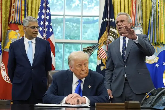 President Donald Trump listens as Health and Human Services Secretary Robert F. Kennedy Jr., speaks as he signs executive orders and proclamations in the Oval Office of the White House, Monday, May 5, 2025, in Washington. Jay Bhattacharya, director of the National Institutes of Health, listens at left. (AP Photo/Alex Brandon)