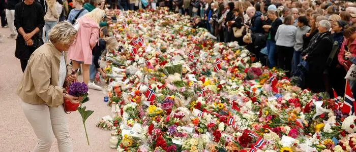Traunernde legen Blumen vor dem Palast nieder