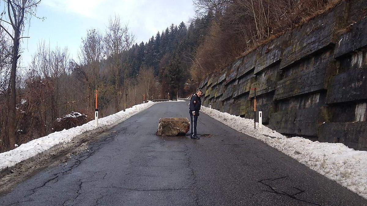 Ein Beamter der Polizeiinspektion Feistritz/Drau zeigt die Stelle, wo der Felsbrocken ein Loch in den Asphalt schlug