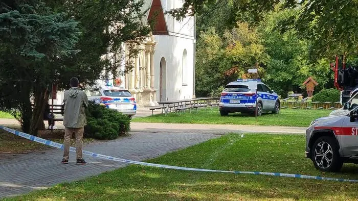 Eine Person Absperrband und Polizeiautos vor dem Benediktinerkloster in Jaroslaw