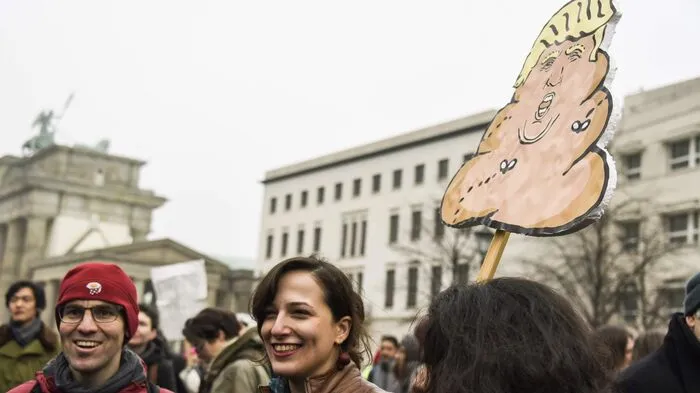 Die Menge vor der US-Botschaft am Brandenburger Tor hielt am Samstag Schilder hoch, auf denen sie ihren Unmut über das Dekret kundtaten.