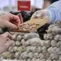 A volunteer offers Salami sausage at the booth of France during the opening day of the Gruene Woche (Green Week) international agriculture fair in Berlin on January 17, 2020. - The fair officially opens on January 17, 2020 and runs until January 26, with Croatia as partner country of the Green Week 2020. (Photo by Tobias SCHWARZ / AFP)