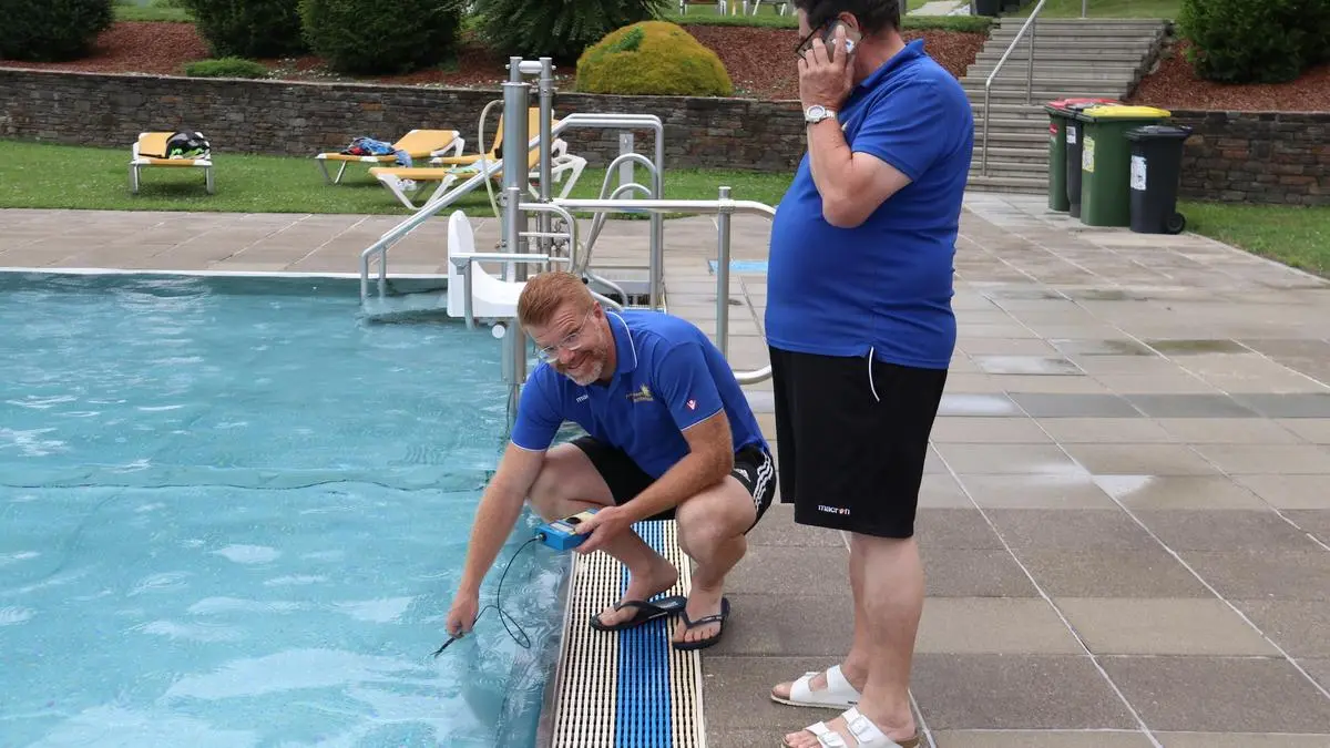 Bürgermeister Harald Bergmann geht Bademeister Hans Facher zur Hand