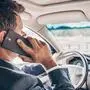 Ein Mann sitzt hinter dem Steuer eines Autos und hält sich das Handy ans Ohr. | Im Bezirk Feldkirchen wurden 110 Personen von der Polizei mit dem Handy am Steuer erwischt