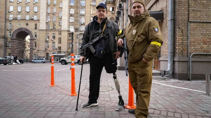 Bewaffnete Zivilisten posieren für ein Foto auf den leeren Straßen von Kiew. Über das gesamte Wochenende herrschte in der ukrainischen Hauptstadt eine Ausgangssperre.   