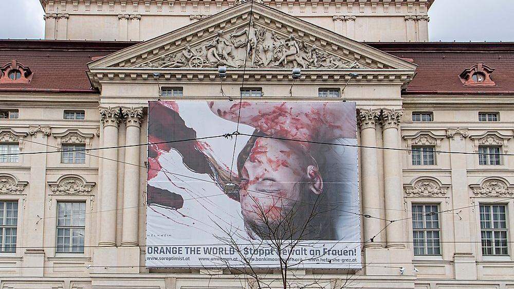 Blutüberströmt und leblos - das Bild eines weiblichen Opfers macht bis zum 10. Dezember auf der Opernfassade auf Gewalt gegen Frauen aufmerksam