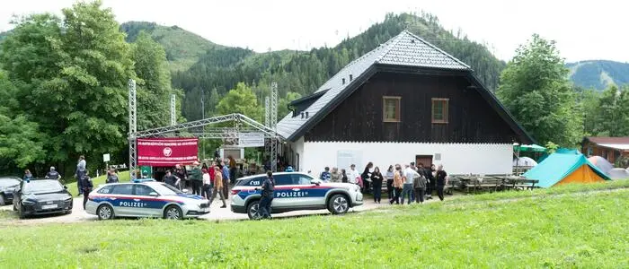 Polizeiautos und Polizisten vor einem alten Bauernhof | Ein Polizeieinsatz am Peršmanhof sorgte für Irritationen