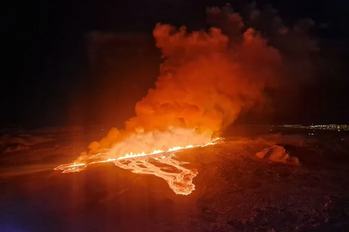 This handout picture released by the Icelandic Coast Guard on February 8, 2024 shows billowing smoke and flowing lava pouring out of a new fissure during a new volcanic eruption on the outskirts of the evacuated town of Grindavik, western Iceland. A volcanic eruption started on the Reykjanes peninsula in southwestern Iceland on Thursday, the third to hit the area since December, authorities said. (Photo by HANDOUT / Icelandic Coast Guard / AFP) / RESTRICTED TO EDITORIAL USE - MANDATORY CREDIT "AFP PHOTO /HANDOUT/ICELANDIC COAST GUARD " - NO MARKETING - NO ADVERTISING CAMPAIGNS - DISTRIBUTED AS A SERVICE TO CLIENTS
