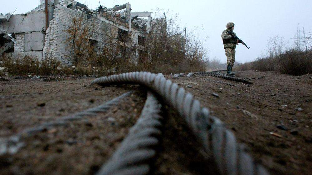 Ein Ukrainischer Soldat patrouilliert neben einer zerstörten Kohle-Mine in Butovka