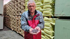 Helmut Buchgraber im PSO-Lager mit Käferbohnen vor Paletten mit Saatgut