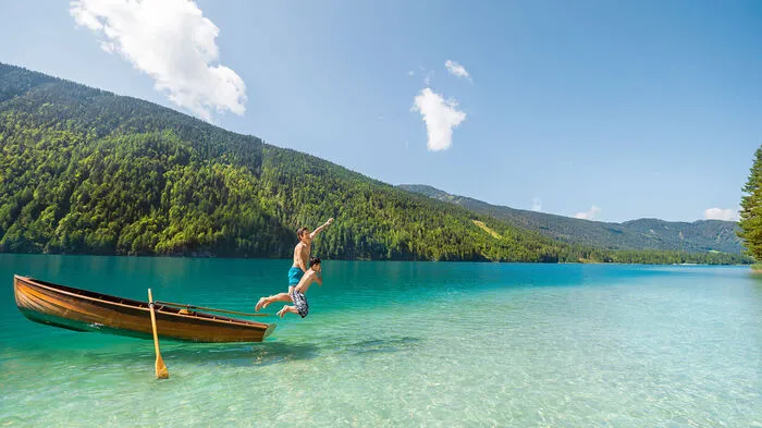 Wer das erste Mal den fjordähnlichen, knapp zwölf Kilometer langen Weißensee erblickt, spürt, dass er hier einen ganz besonderen Kraftort vor sich hat. Das glasklare Wasser spiegelt von türkisblau bis dunkelgrün und lädt zu einem Sprung in das bis zu 24 Grad erfrischende Wasser. Der höchst gelegene Badesee Europas ist das Herzstück des 76 Quadratkilometer großen gleichnamigen Naturparks, der als „Spielplatz der Natur“ 365 Tage im Jahr zum Spielen in der atemberaubenden Naturkulisse lädt.