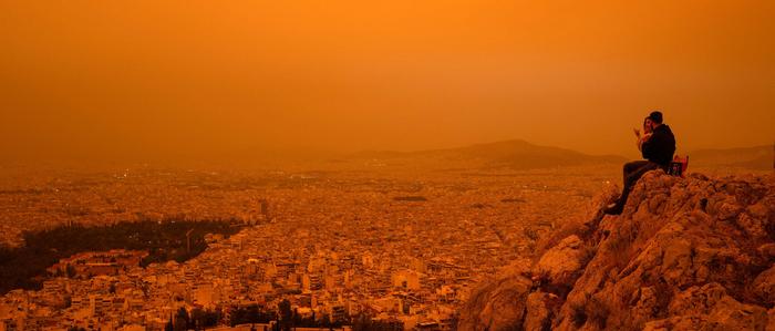 Saharastaub in Athen | Ein Paar sitzt auf dem Hügel von Tourkovounia, während der Südwind Saharastaub heranträgt.