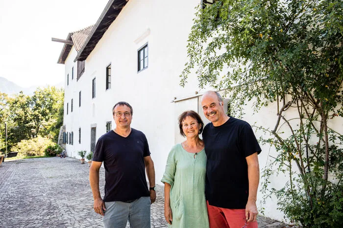 Ed Hoke (rechts) mit seiner Frau Ulrike und Bruder Armin Guerino vor Schloss Saager. Zusammen mit Bruder Tomas Hoke lenken sie heute die Geschicke des historischen Hauses.