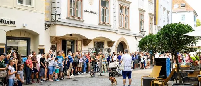 Eine Schar Touristen blickt gebannt nach oben, um das Spektakel zu verfolgen