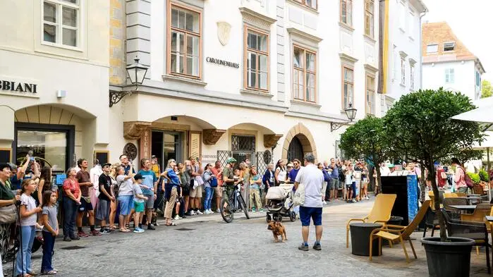 Eine Schar Touristen blickt gebannt nach oben, um das Spektakel zu verfolgen