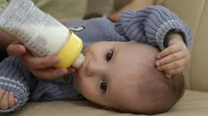 Junge Mutter füttert Baby mit der Flasche