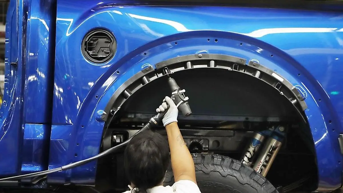 FILE- In this Sept. 27, 2018, file photo a United Auto Workers assemblyman works on a 2018 Ford F-150 truck being assembled at the Ford Rouge assembly plant in Dearborn, Mich. Ford Motor Co. said Thursday, Feb. 4, 2021, that it will cut shifts at two of its U.S. manufacturing plants next week, due to the worldwide chip shortage that has also impacted other automakers. Ford will cut shifts at its Dearborn, Mich., facility and  Kansas City, Mo., plant; both produce the F-150 pickup truck, Ford's most popular model and part of the F-Series, the top-selling vehicle in the U.S. (AP Photo/Carlos Osorio, File)